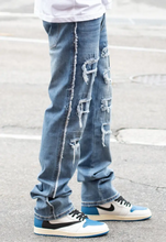 Load image into Gallery viewer, Expertly crafted with a mid high thread count for superior softness and durability, our exclusive Side Raw Edge Rip &amp; Repair Raw Denim Jeans are a must-have for any wardrobe. The slim fit and comfort-stretched denim offer both style and comfort, while the distressed details and raw edges add a touch of edge to any look. Made with 97% cotton and 3% spandex, these indigo blue jeans are the perfect addition to your wardrobe.
