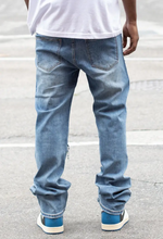 Load image into Gallery viewer, Expertly crafted with a mid high thread count for superior softness and durability, our exclusive Side Raw Edge Rip &amp; Repair Raw Denim Jeans are a must-have for any wardrobe. The slim fit and comfort-stretched denim offer both style and comfort, while the distressed details and raw edges add a touch of edge to any look. Made with 97% cotton and 3% spandex, these indigo blue jeans are the perfect addition to your wardrobe.
